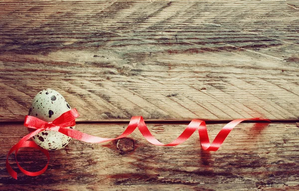 Quail easter egg with red ribbon — Stock Photo, Image