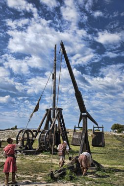 Medieval warriors loading catapult clipart