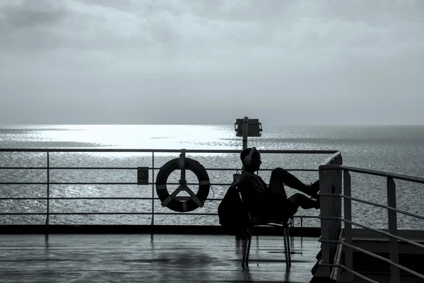 Mann hört Musik mit Kopfhörer auf Schiff — Stockfoto
