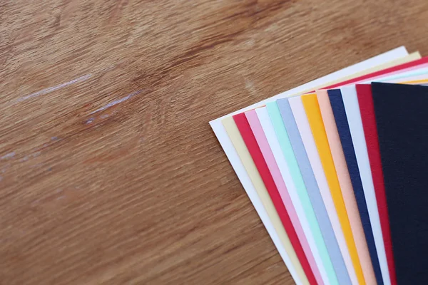 Papel a cores sobre fundo de madeira — Fotografia de Stock