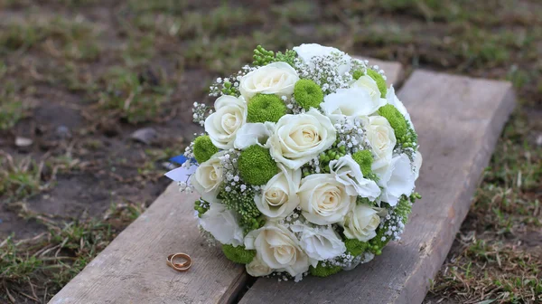 결혼 반지와 나무 보드에 꽃다발 — 스톡 사진