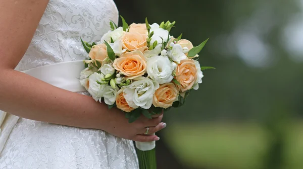 Mãos de noiva segurando lindo buquê de casamento — Fotografia de Stock