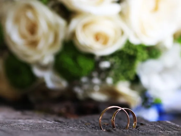 Anneaux de mariage sur une planche en bois — Photo