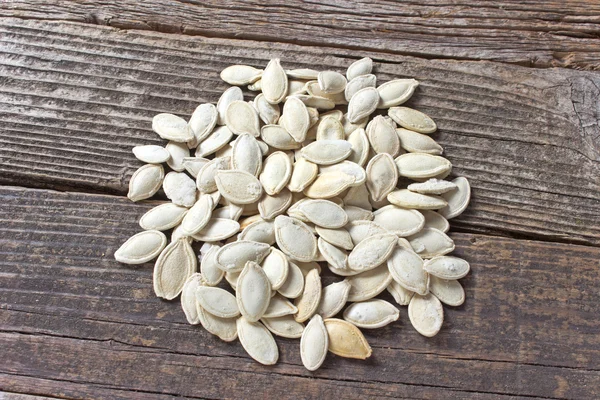 Підсмажене гарбузове насіння на дерев'яному фоні — стокове фото
