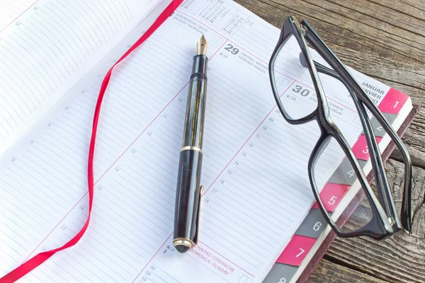 Fontän penna och anteckningsbok planner med glasögon — Stockfoto