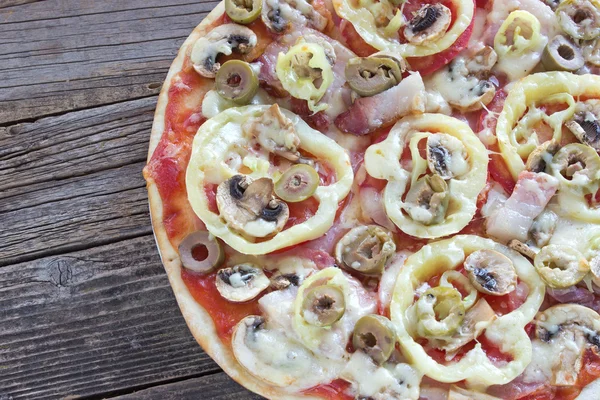 Close up of fresh pizza on wooden board — Stock Photo, Image