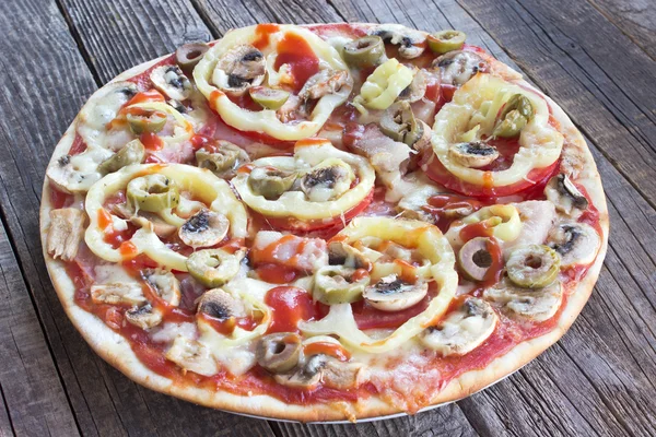 Whole pizza on wooden board — Stock Photo, Image