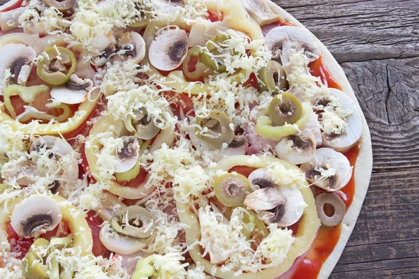 Raw pizza with ingredients and cheese — Stock Photo, Image