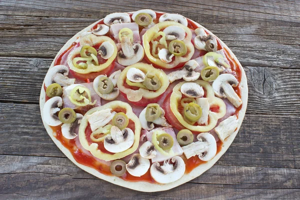 Raw pizza with  ingredients on wooden table — Stock Photo, Image