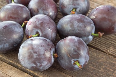 Ahşap arka plan üzerinde olgun Erik