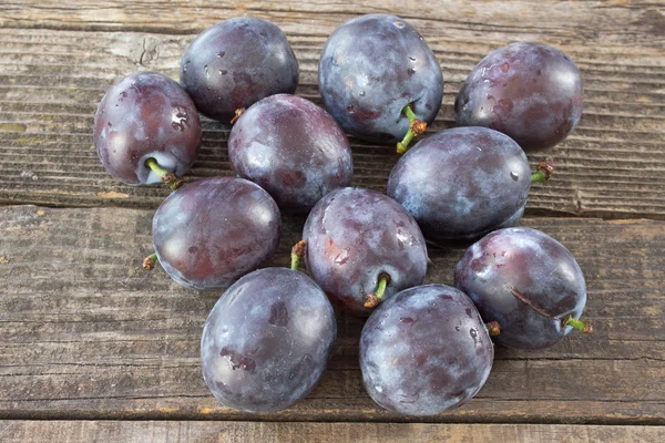 Ripe plums on wooden background — Stock Photo, Image