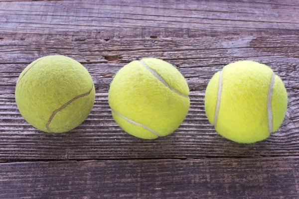 Three used tennis balls on wooden background — Stock Photo, Image