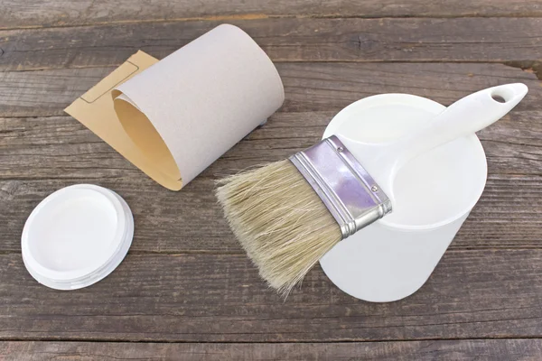 White enamel paint with brush and sandpaper on old wood — Stock Photo, Image