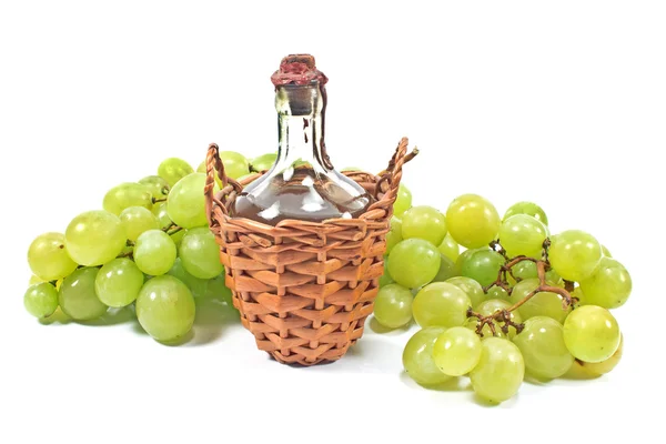 Vecchia bottiglia sigillata di vino e uva bianca isolata su bianco — Foto Stock