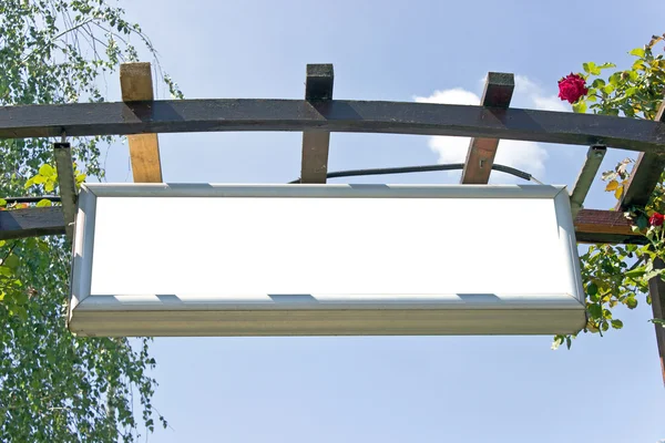 Cartel blanco en blanco sobre arco de madera sobre cielo — Foto de Stock