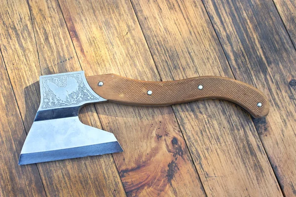 Velho machado sobre fundo de madeira — Fotografia de Stock