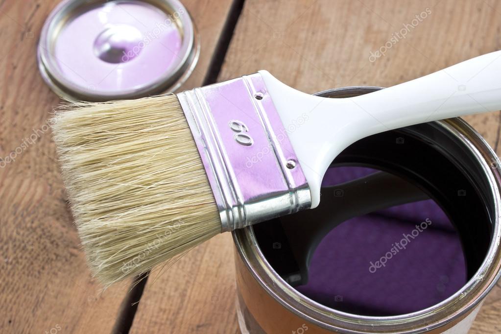 Paint brush and varnish can on wooden background