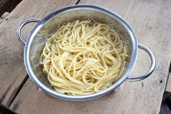 Süzgeç ahşap masa üzerinde taze pişmiş spagetti — Stok fotoğraf