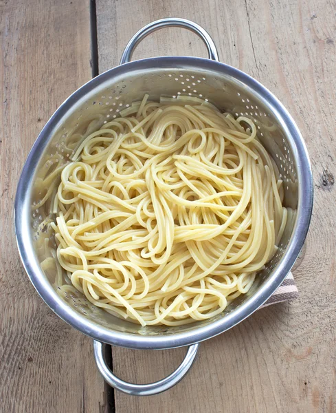 Süzgeç ahşap masa üzerinde taze pişmiş spagetti — Stok fotoğraf