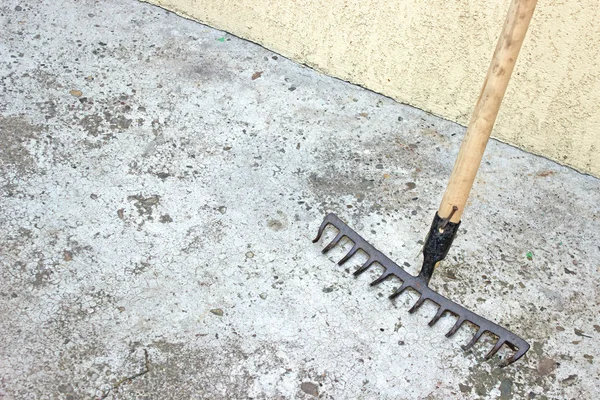 Rake tool over concrete background — Stock Photo, Image