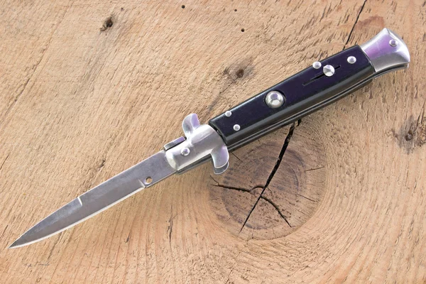 Switchblade knife na drewniane tła — Zdjęcie stockowe