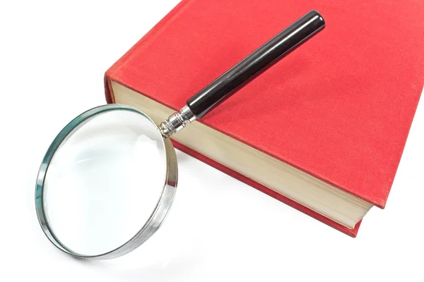 Antique magnifying glass on red book — Stock Photo, Image