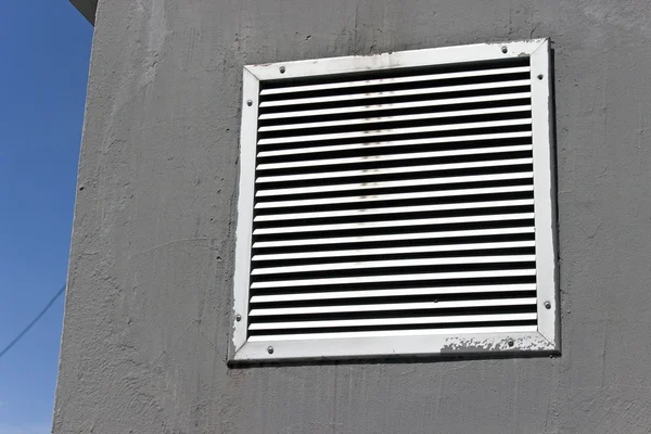 Vent window on gray concrete wall with blue sky — Stock Photo, Image
