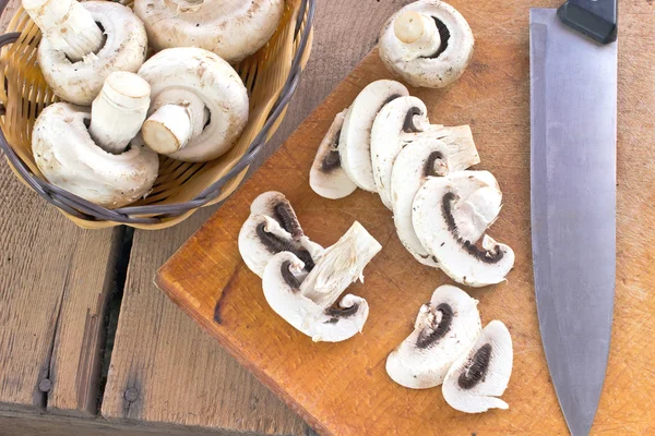 Fresh mushrooms on wooden board with knife — Stock Photo, Image