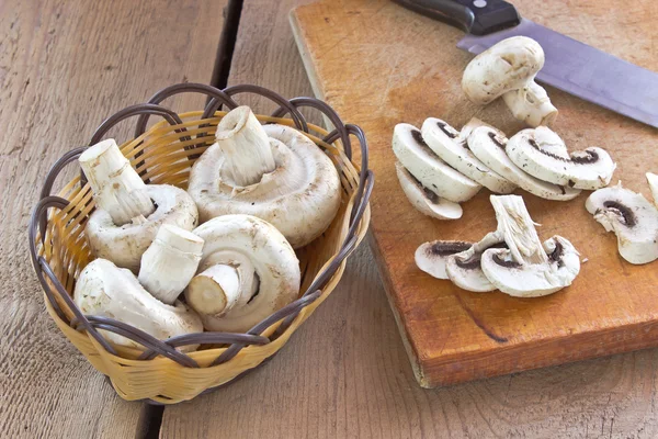 Champignons frais sur planche de bois avec couteau — Photo