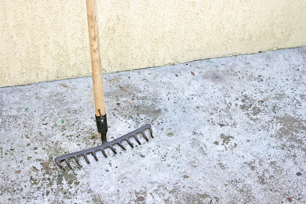 Ferramenta ancinho sobre fundo de concreto — Fotografia de Stock