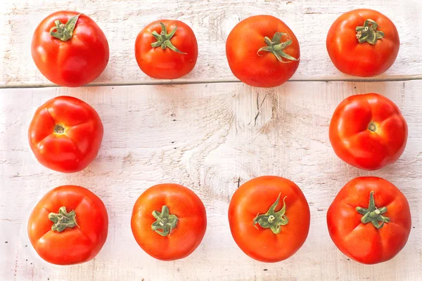 Tomatoes on white wooden surface — Stock Photo, Image