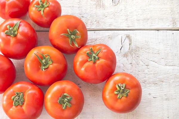 Tomatoes on white wooden surface — Stock Photo, Image