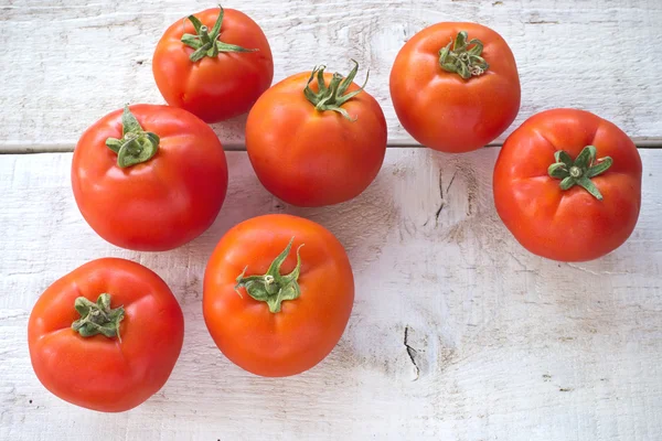 Tomatoes on white wooden surface — Stock Photo, Image