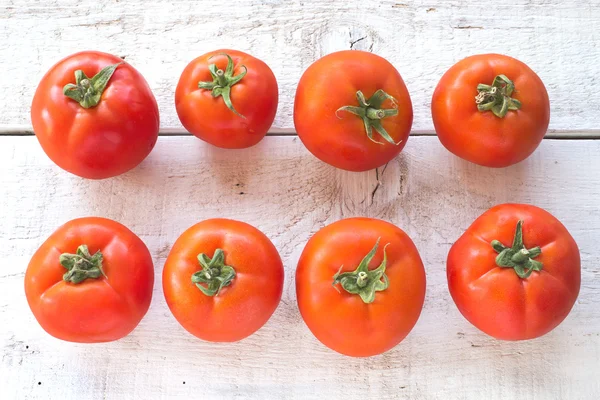 Tomatoes on white wooden surface — Stock Photo, Image