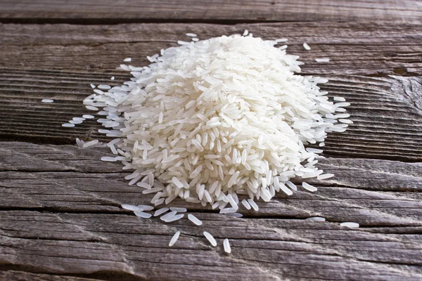 Pile of rice on wooden background