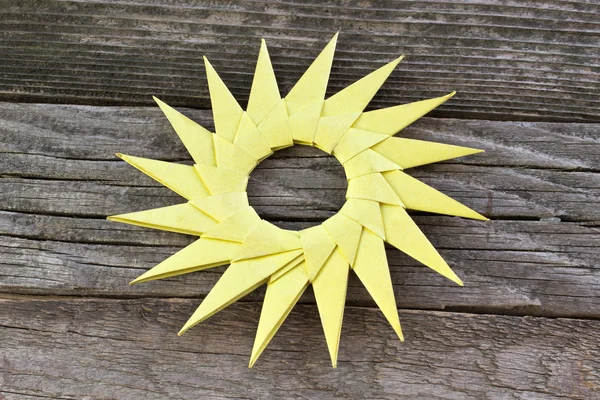 Origami gelbe Papiersonne auf hölzernem Hintergrund — Stockfoto