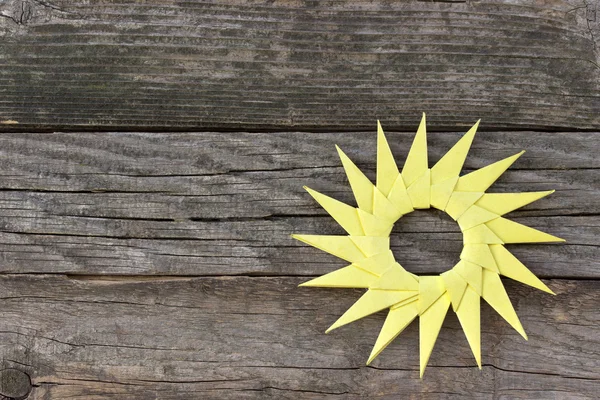 Origami sol de papel amarelo no fundo de madeira — Fotografia de Stock