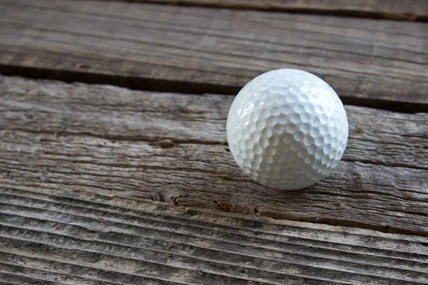 Old used golf ball on wooden background — Stock Photo, Image