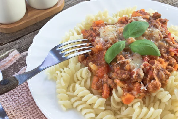 Pasta Fusilli pasta with bolognese sauce on kitchen table — Stock Photo, Image