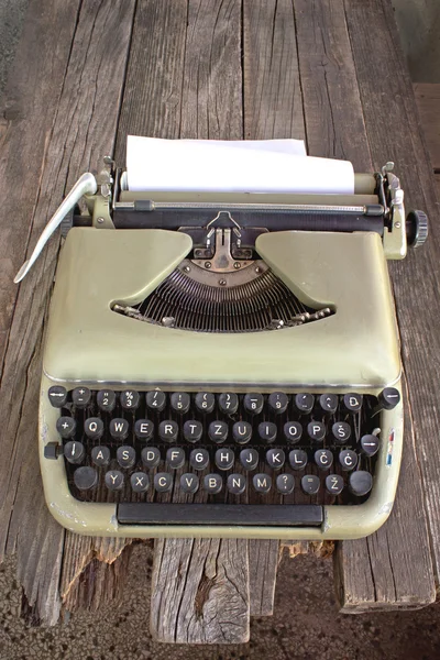 Vecchia macchina da scrivere con carta bianca su sfondo di legno — Foto Stock