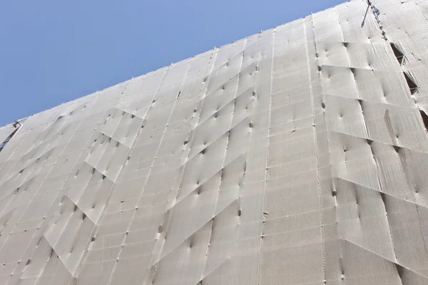 Construcción de edificios - andamios con protección de lino sobre s — Foto de Stock