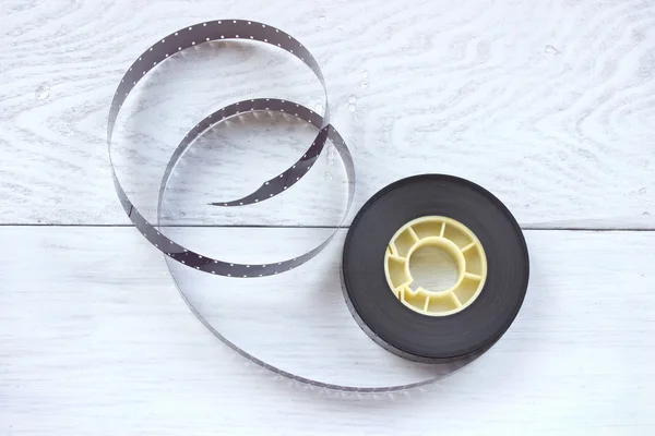 Beyaz ahşap zemin üzerine 16mm film reel — Stok fotoğraf