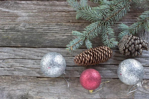 ลูกบอลคริสต์มาส, ก้อนสนและเข็มบนพื้นหลังไม้ — ภาพถ่ายสต็อก
