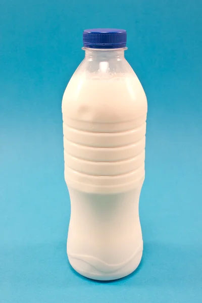 Flasche Milch isoliert auf blauem Hintergrund — Stockfoto