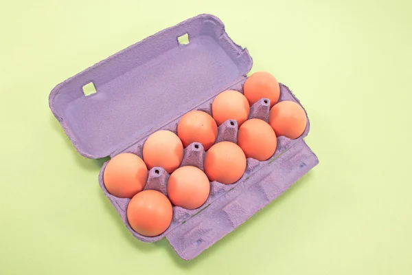 Eier in Karton isoliert auf grün — Stockfoto