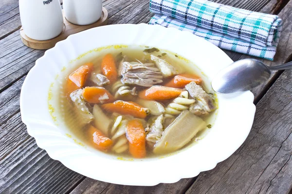 Суп из говядины и овощей на деревянном фоне — стоковое фото