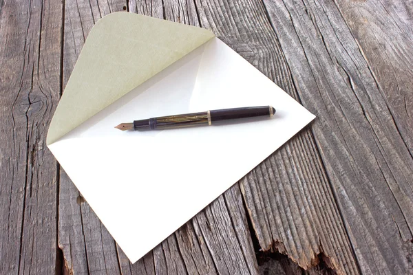 Caneta-tinteiro e carta sobre fundo de madeira — Fotografia de Stock