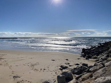 Atlantik Okyanusu dalgaları Costa de Caparica 'nın güzel sahil şeridine çarpıyor.