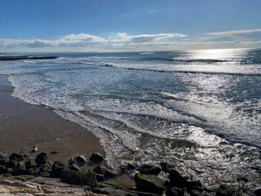 Atlantik Okyanusu dalgaları Costa de Caparica 'nın güzel sahil şeridine çarpıyor.