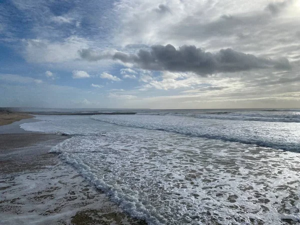 Atlantik Okyanusu dalgaları Costa de Caparica 'nın güzel sahil şeridine çarpıyor.